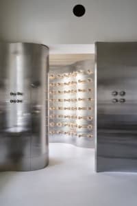 Minimalist interior with metallic aluminum walls and light bulbs on the wall