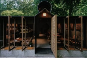 Outdoor seating area of a modern restaurant featuring wooden panels and seating.