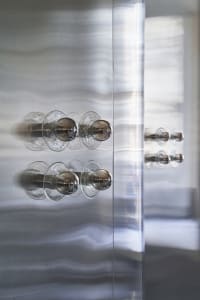 Close-up of modern interior handles featuring glass and metal materials