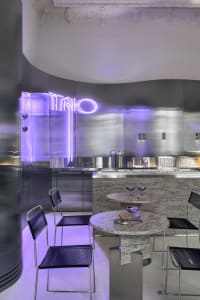 A modern metallic restaurant interior with reflective surfaces and industrial lighting.