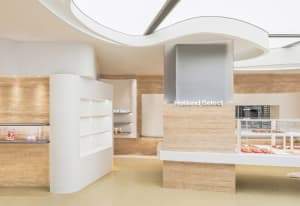 A modern, minimalist retail shop with white marble walls and floors.