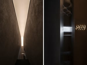 A modern stairwell with concrete walls and illuminated lighting fixtures.