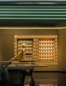 Modern coffee shop with a minimalist interior and wooden display centerpieces showcasing a variety of coffee options.