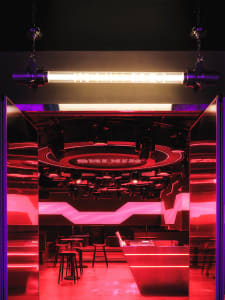 A brightly lit dance floor with metallic elements and red lighting.