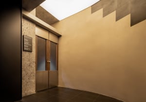 A minimalist office entrance featuring metal and glass elements.