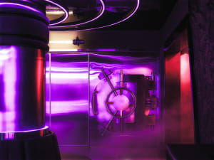 Metal lobby with purple illumination and a vault door