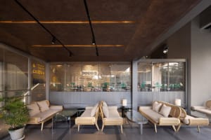 A modern, minimalist coffee shop interior with industrial design elements, featuring concrete and glass materials.