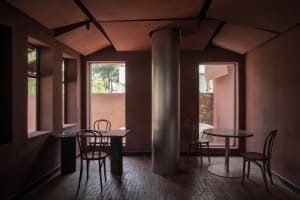 Minimalist cafe interior with marble tables and chairs, featuring a sleek, modern design with large windows and a central col