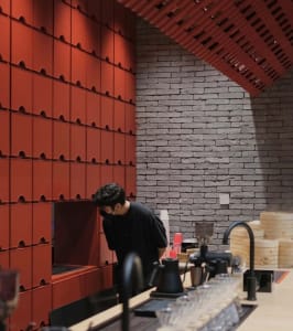 A modern cafe interior featuring brick and concrete materials.
