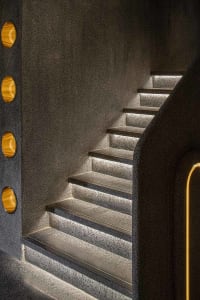 A modern staircase with concrete steps illuminated by built-in lighting.