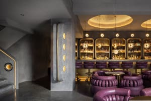 A modern restaurant bar with concrete and metal finishes.