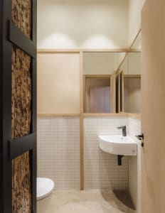 Industrial-style washroom with tiled walls and wooden accents