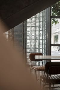 Modern cafe interior featuring glass block wall and concrete detailing.