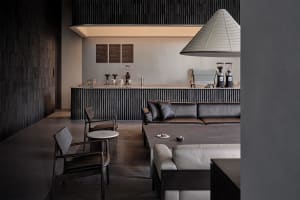 A modern industrial coffee shop interior with concrete flooring, wooden accents, and coffee grinders on the counter.