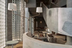 Interior of a modern industrial coffee shop featuring concrete and glass materials.