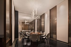 Modern restaurant interior with wooden tables, metal chairs, and glass lighting fixtures.