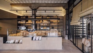 Modern bakery interior featuring concrete, wood, and glass materials