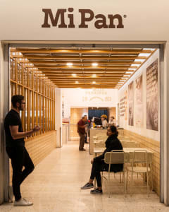 A spacious, modern fast food restaurant interior featuring tiled flooring and wooden accents.
