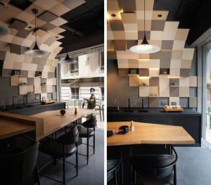 A modern cafe interior with a checkerboard pattern ceiling and wood accents.