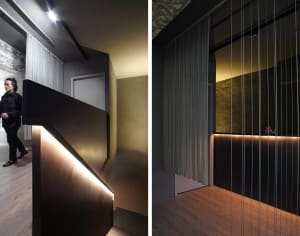 A modern residential stairwell featuring a metal railing and wooden steps.