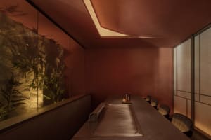 A minimalist restaurant interior featuring a brick counter and seating area.