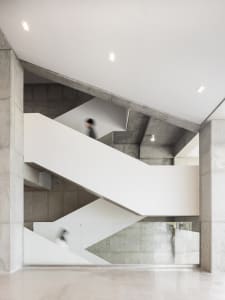 A minimalist modern staircase constructed of concrete and glass.