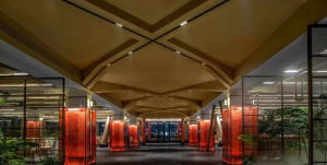 A modern office with glass walkways and red pillars.