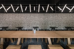 A minimalist cafe interior featuring wooden and concrete surfaces.