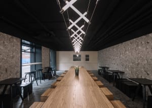 A minimalist coffee shop interior featuring wooden and concrete surfaces.