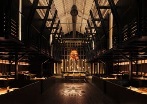 Modern restaurant interior with wooden materials and a dramatic central feature.