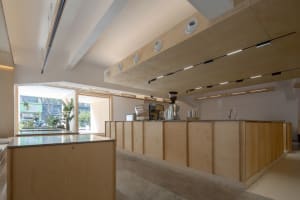 Modern minimalist coffee shop interior with a wooden counter and sleek design.