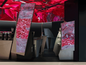 An image showcasing a modern coffee shop interior with digital displays featuring rose petals and a red ceiling.