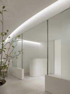 A minimalist reception desk constructed from concrete and glass.
