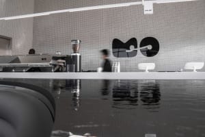 Modern coffee shop interior with a sleek concrete and glass counter.