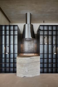 Modern kitchen with metal and stone elements, featuring a sleek countertop and minimalist design.