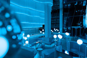 A modern bar with sleek, glass furnishings and contemporary lighting.