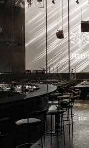 A modern bar interior featuring metallic materials and minimalist design.