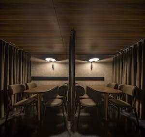 Restaurant interior with wooden walls, leather seating, and fabric curtains