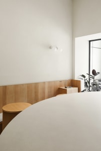 Minimalist café interior featuring wooden surfaces and concrete elements.