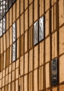 Modern exterior featuring a pattern of brick tiles with metallic insets for a unique design.