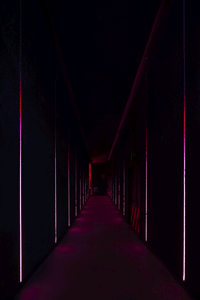 A modern corridor illuminated by light strips.