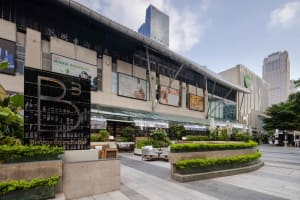 Modern retail storefront featuring glass, concrete, and metal materials.