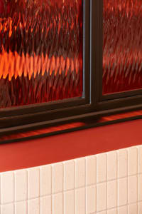 A close-up view of a window displaying reflections and the play of light and shadows.