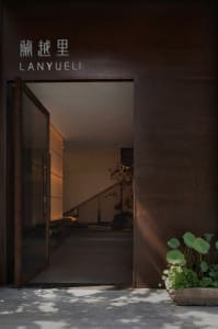 Modern metal entrance with glass door and planters