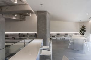 A modern office space with concrete walls and glass furnishings