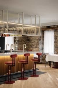 A modern restaurant bar featuring wood, glass, and stone materials with stylish red bar stools.