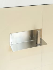 A modern metal locking device attached to a tiled wall.