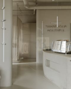 Industrial-style coffee shop interior featuring a sleek concrete counter with a coffee brewing equipment.