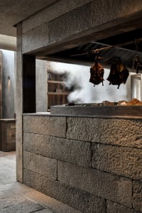 Industrial kitchen with stone countertops and exposed brick walls.