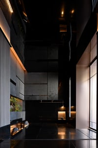Modern hotel lobby featuring sleek, minimalist design with concrete and glass materials.